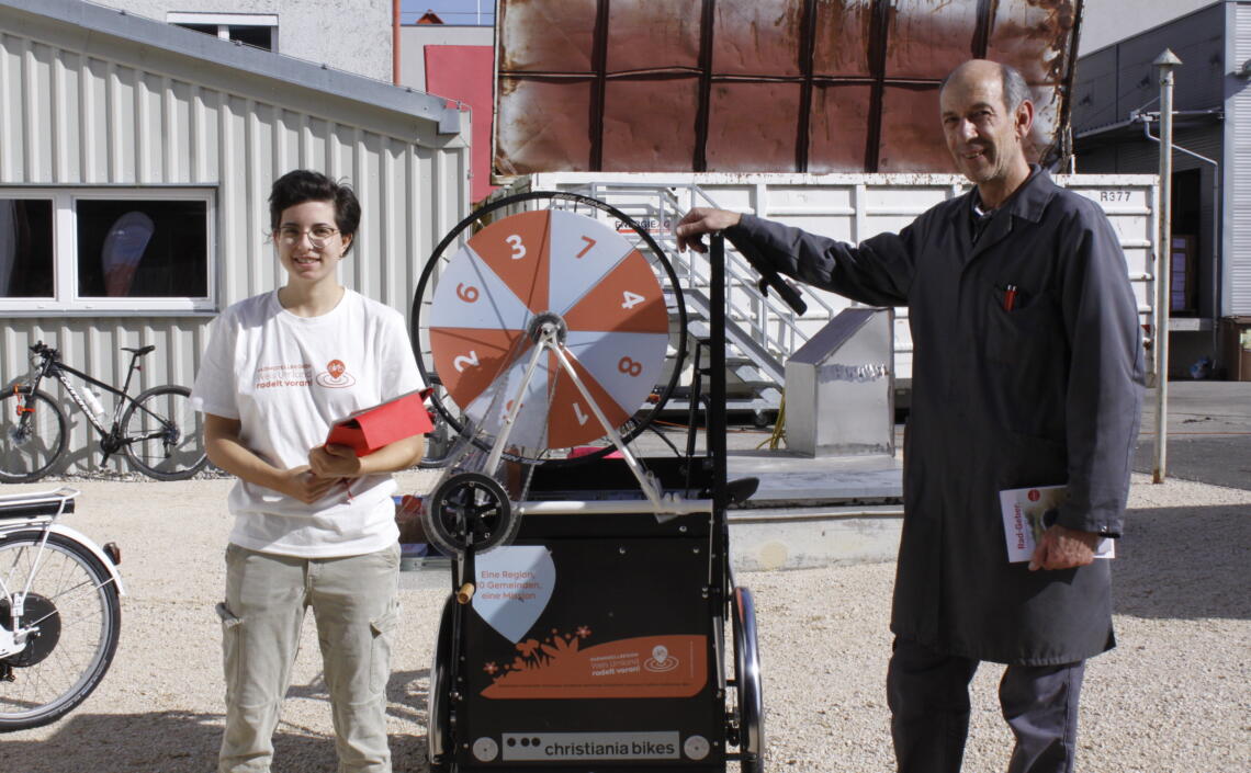 Promotorin mit dem Transportrad als Infostand zu Besuch bei der Firma Trodat, neben ihr Mitarbeiter der Firma