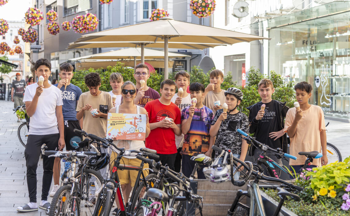 Gruppe von Schüler steht mit Fahrrädern und genießt Eis von der Aktion Radfahren als Hausaufgaben.