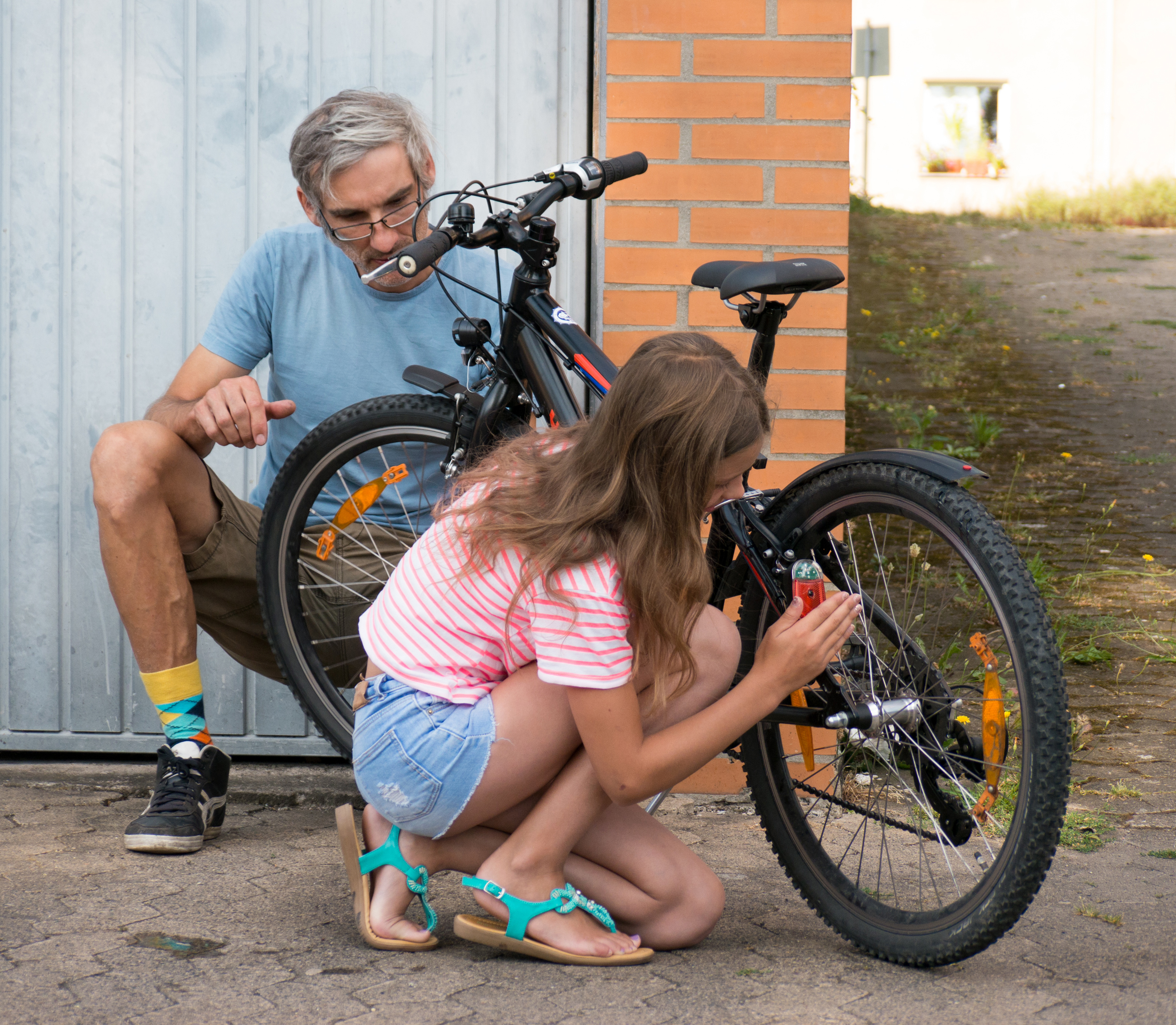 Vater und Tochter testen Rücklicht beim Fahrrad.