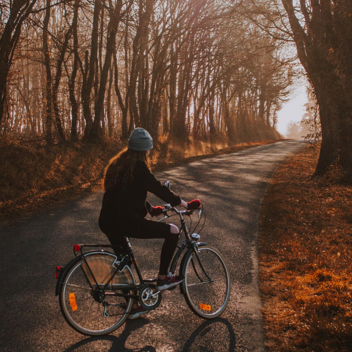 Dame fährt mit Fahrrad bei Herbstlandschaft