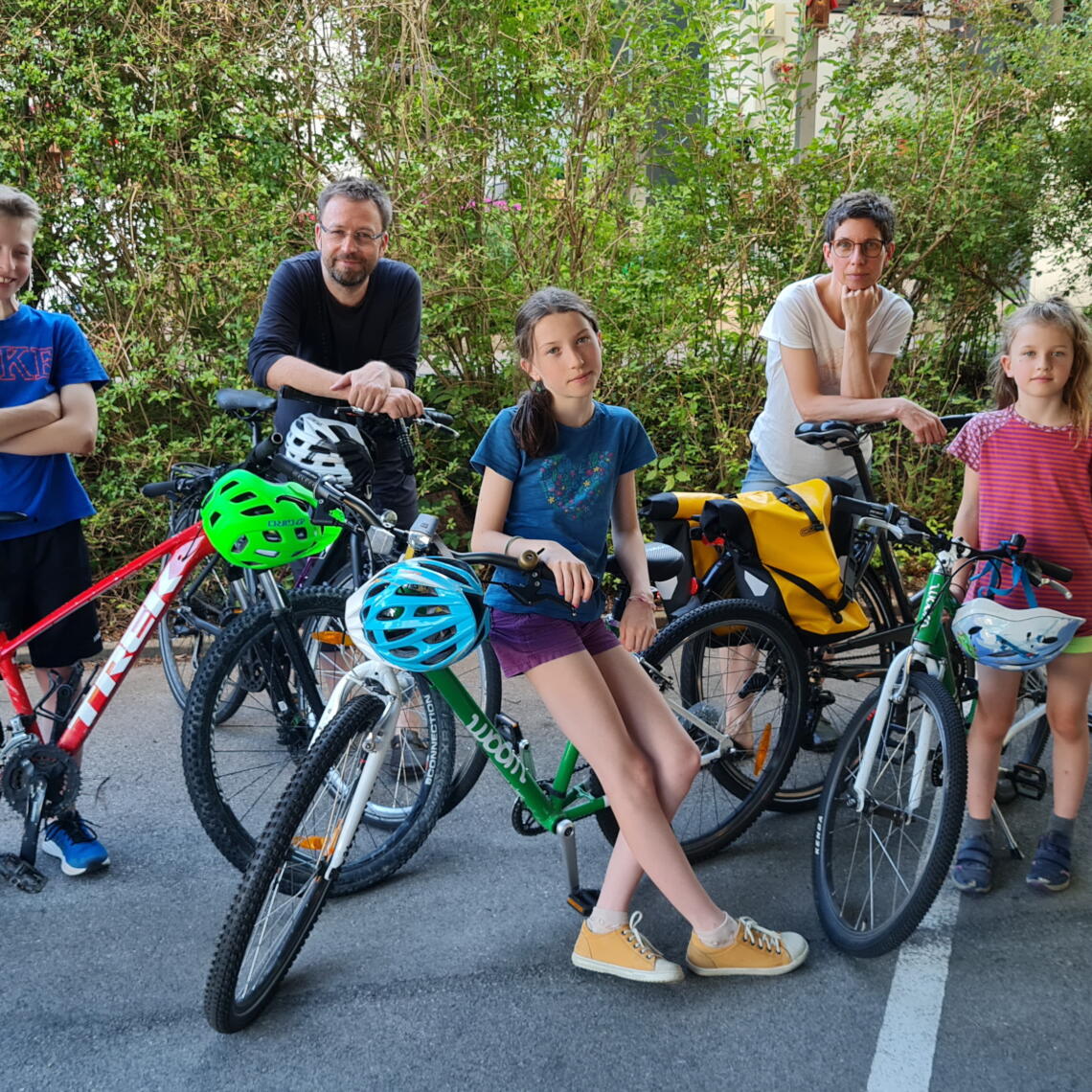 3 Kinder/Jugendliche und 2 Erwachsene posieren mit Fahrrädern
