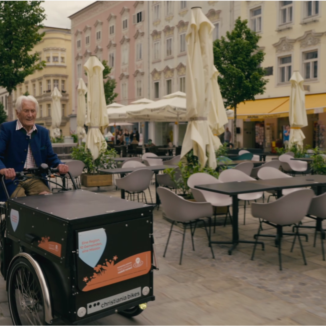 Älterer Herr fährt mit Lastenrad