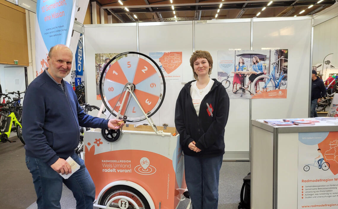 Dame und Herr stehen bei dem Glücksrad bei der Radmesse in Wels