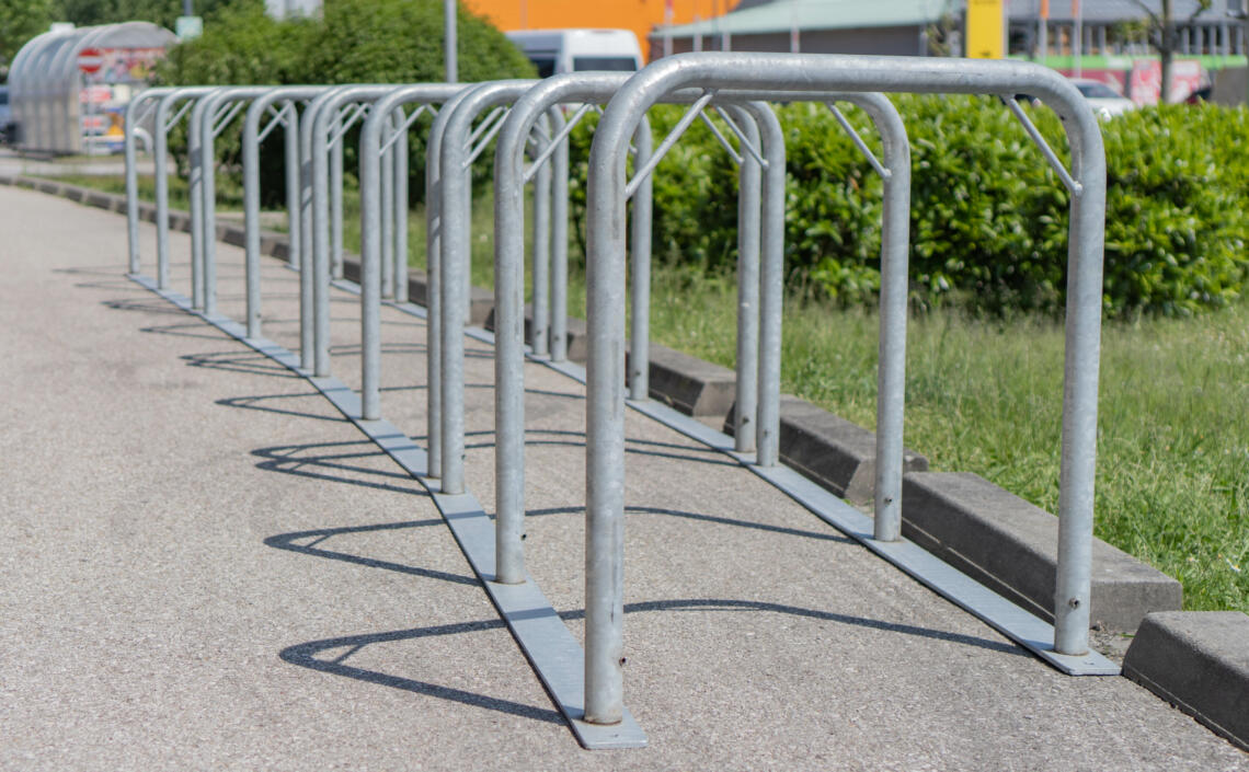 graue Fahrradständer auf einem Geschäftsparkplatz