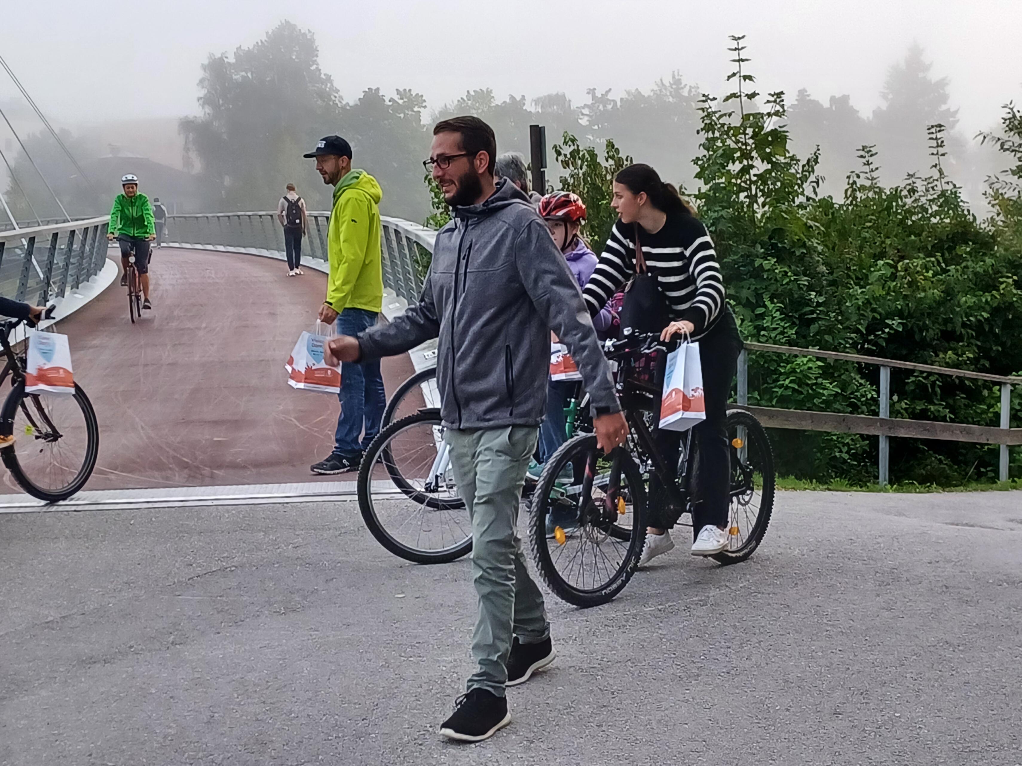 Fahrradfahrer bei einer Brücke mit Danke-Sackerl