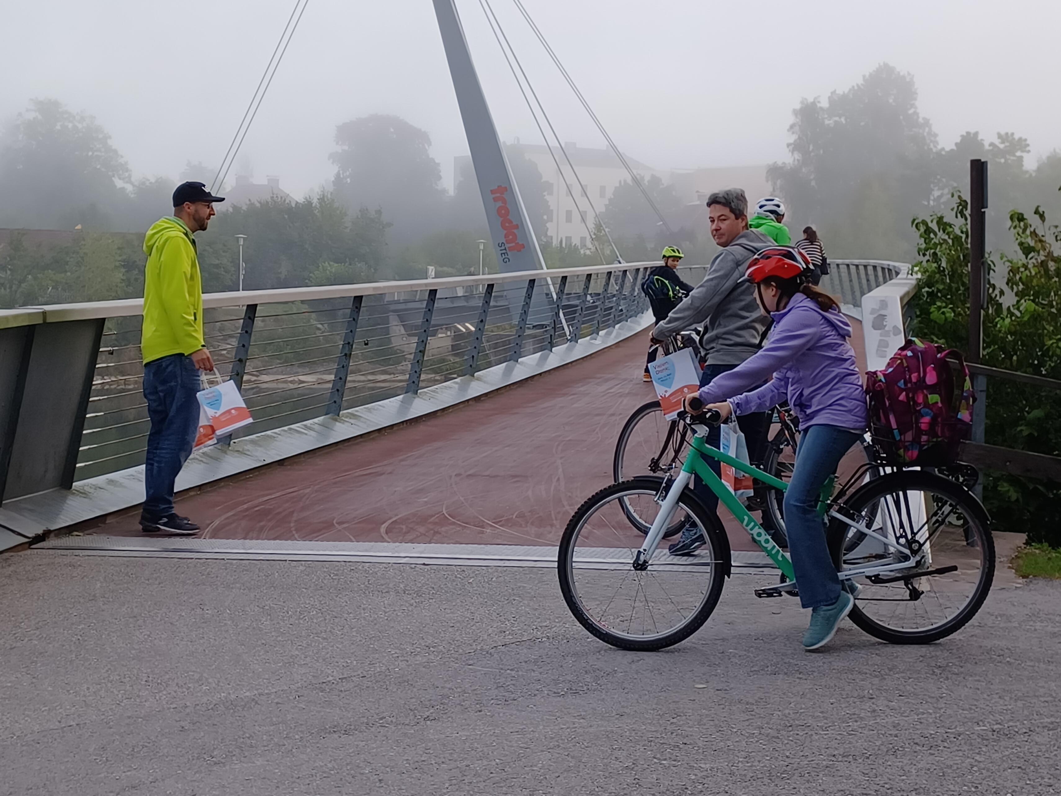 Fahrradfahrer bei einer Brücke mit Danke-Sackerl