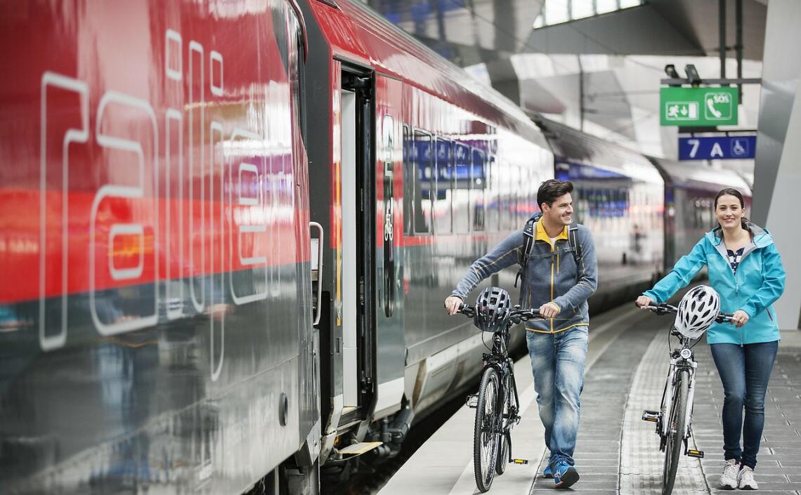 paar mit Fahrrädern am Bahnsteig ÖBB Railjet