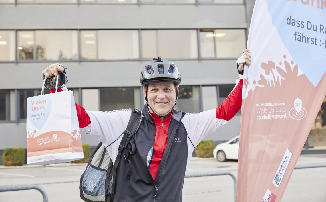 Mann auf Fahrrad und mit Früstückssackerl