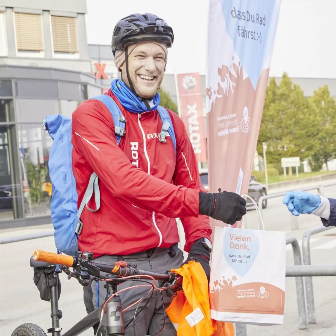 Mann auf Fahrrad mit Früstückssackerl