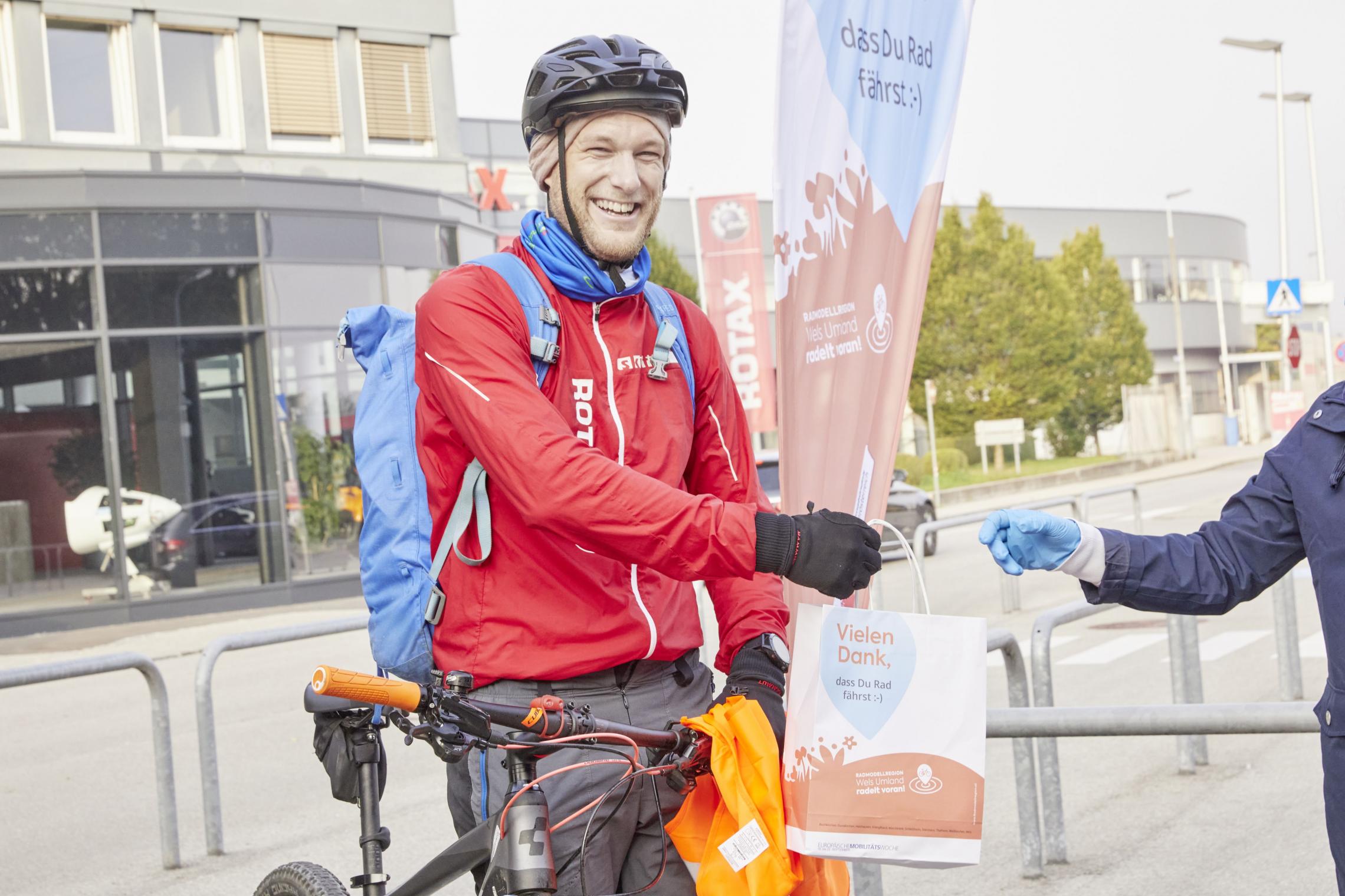 Mann auf Fahrrad mit Früstückssackerl