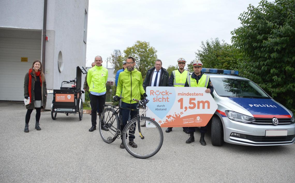 Personen mit Fahrrädern und Rücksicht durch Abstand Schild