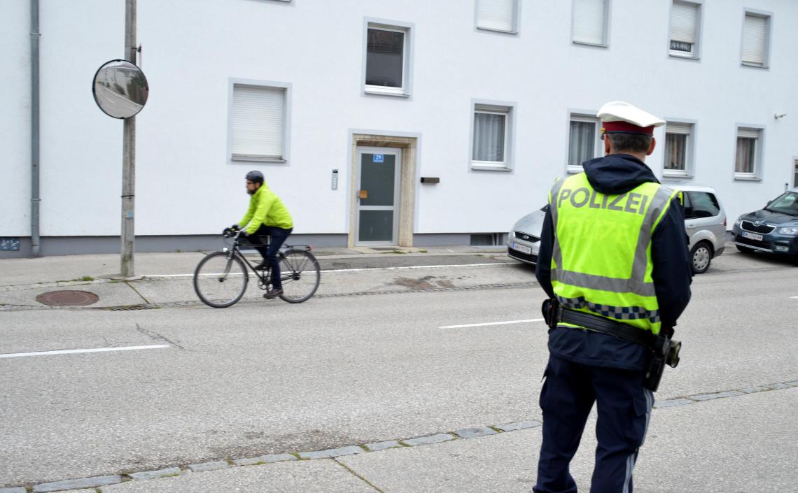 Mann auf Fahrrad wird von Polizist beobachtet
