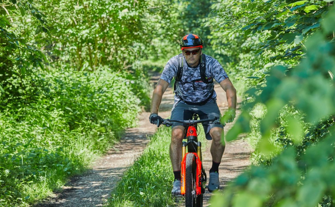 Mann auf Fahrrad auf Schotterstraße