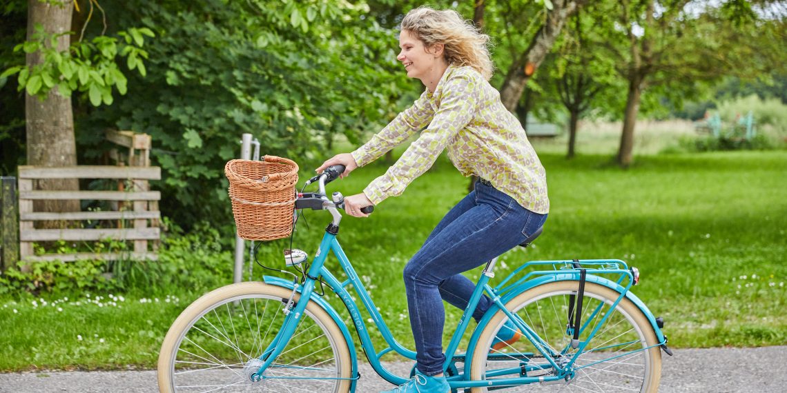 Frau auf Fahrrad und Korb