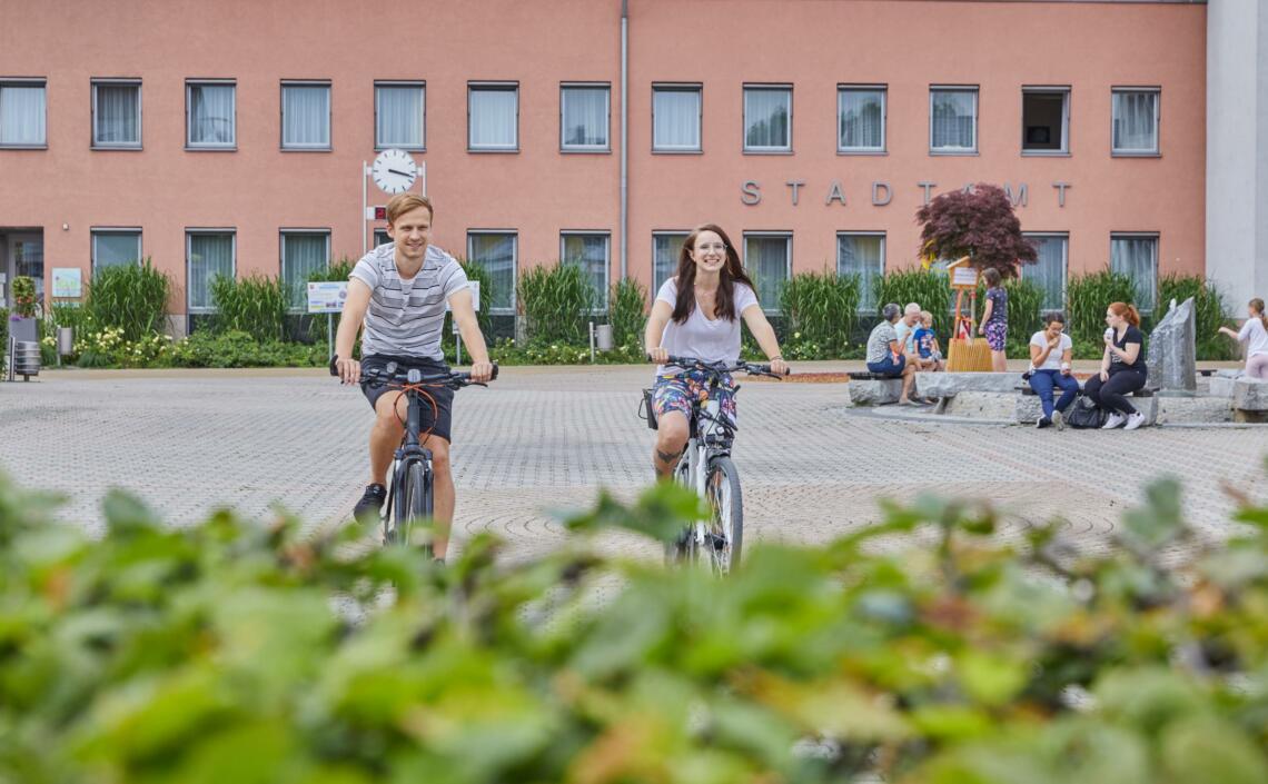 Personen auf Fahrrädern auf Platz vor Stadtamt