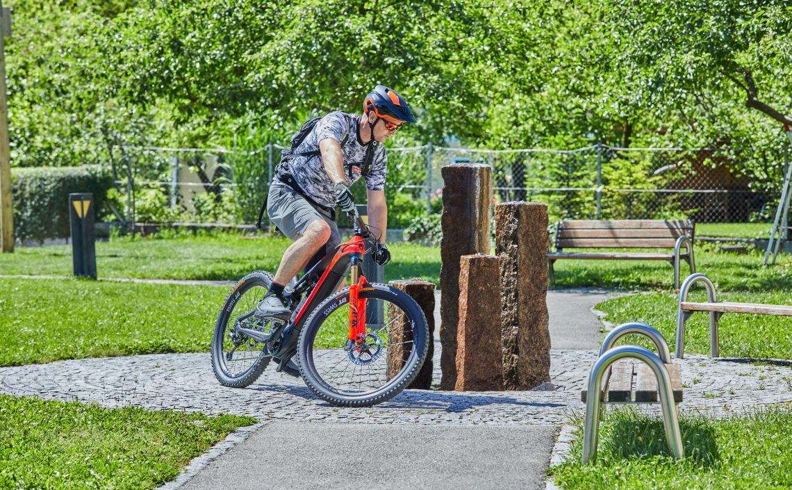 Mann auf Fahrrad fährt rund um Brunnen