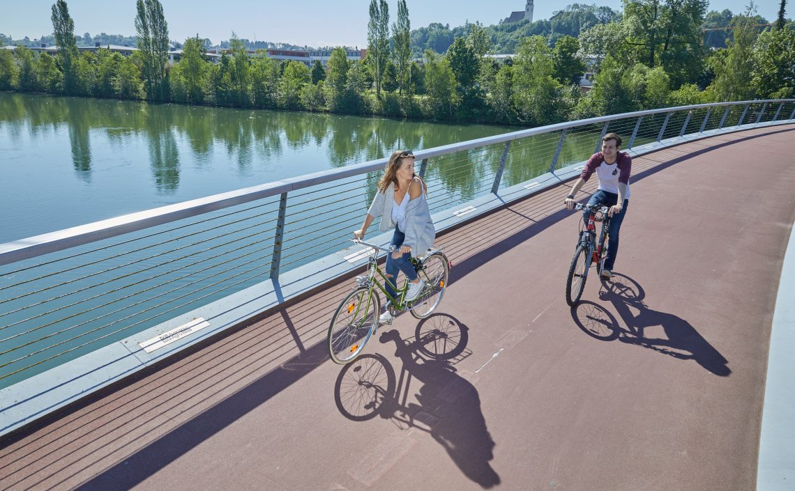 Personen auf Fahrrädern auf Brücke